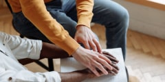 person in yellow long-sleeved shirt guiding the hands of another person