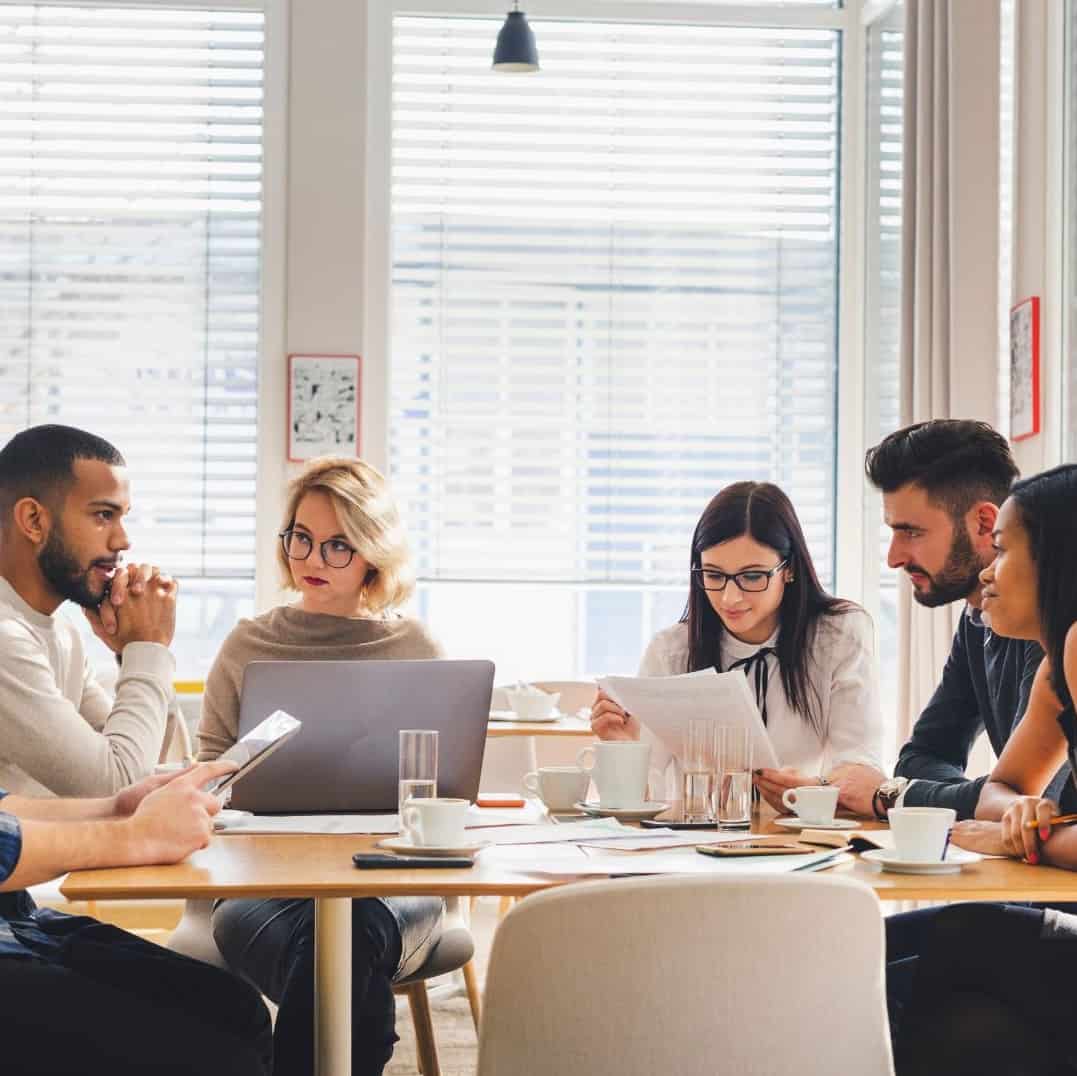 team members sitting around a table collaborating