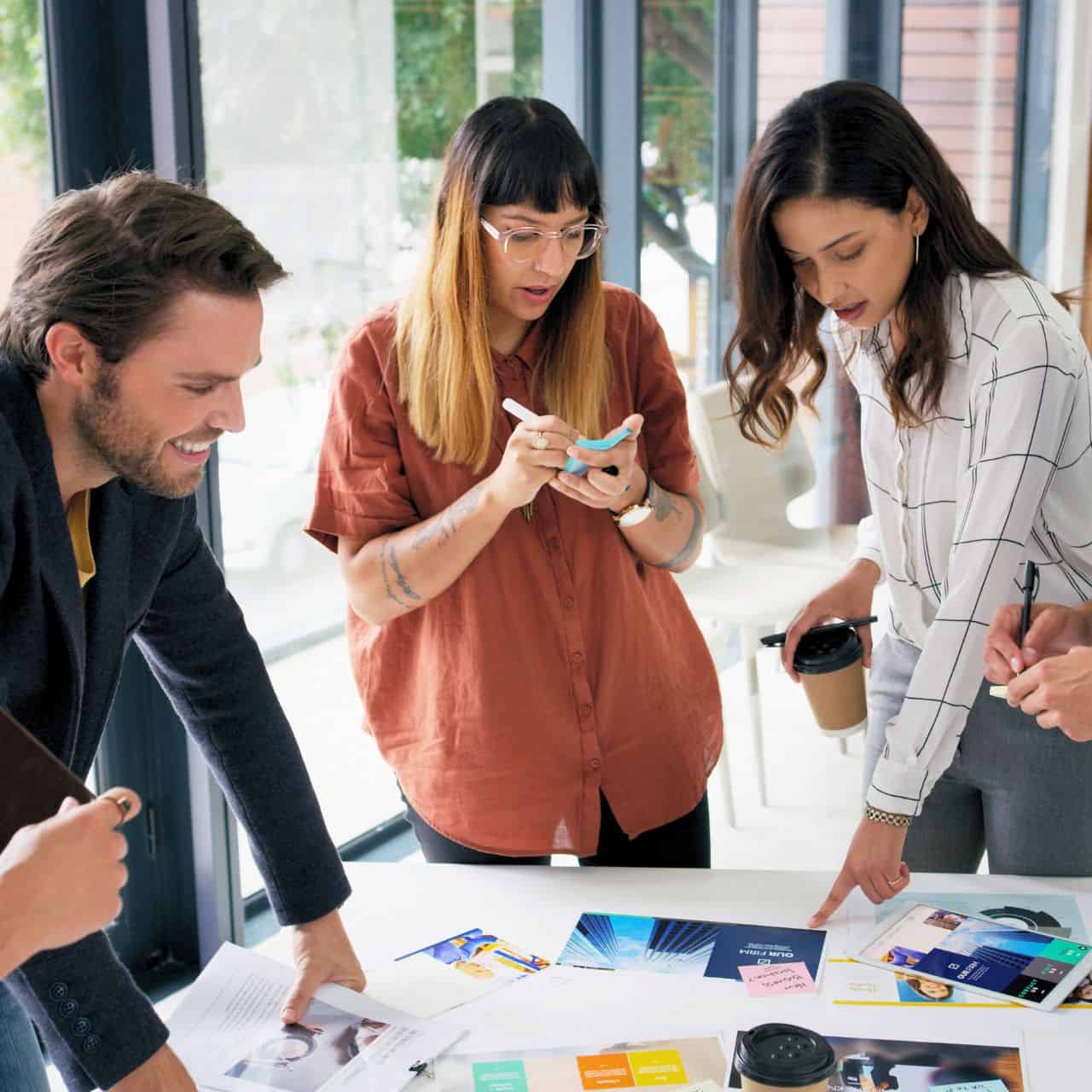 people standing around table brainstorming