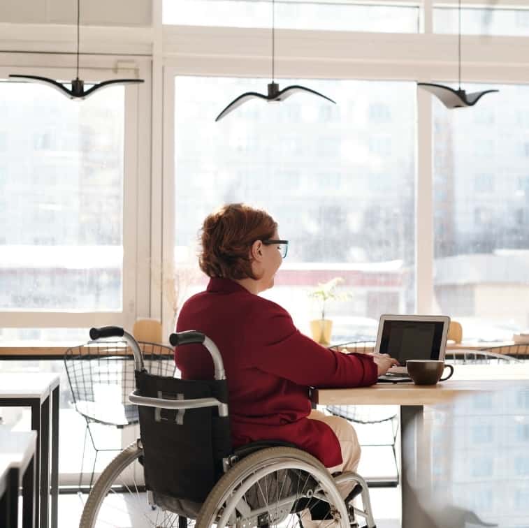 lady in a wheelchair on her laptop in a cafe