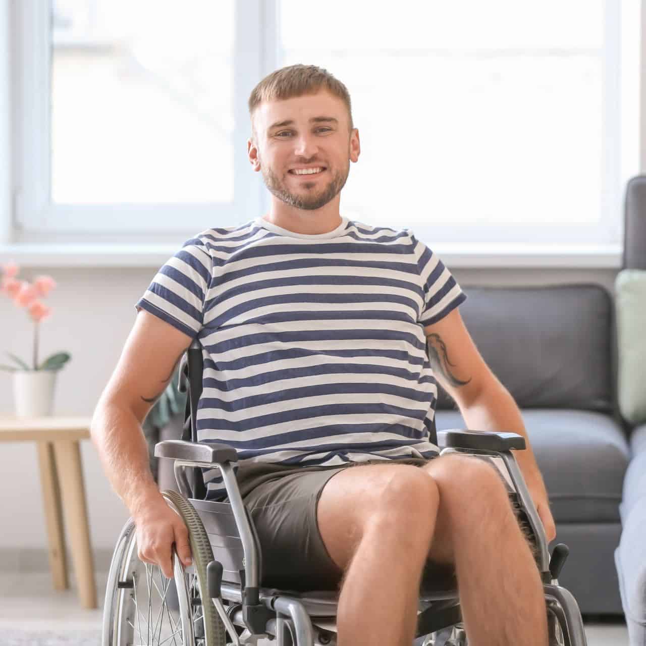 young man in wheelchair in his home smiling at the camera