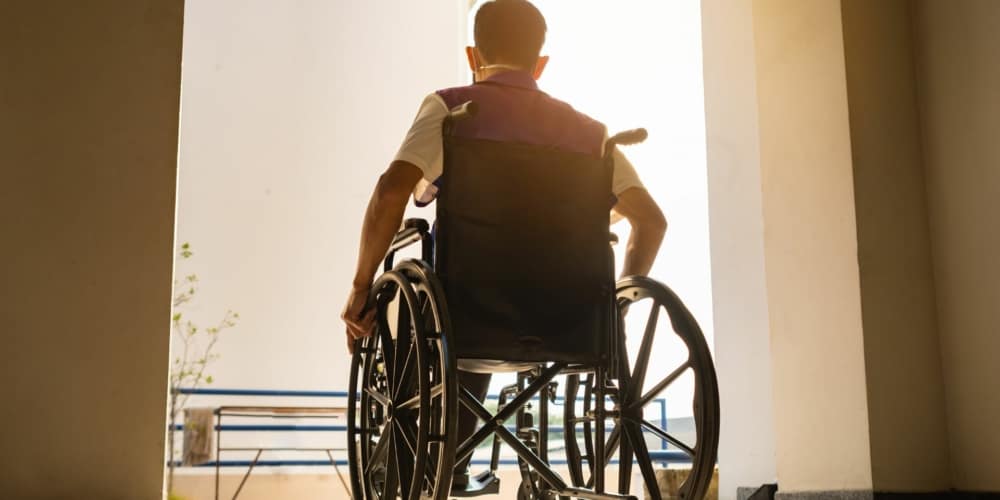 image of a man entering a room in a wheelchair