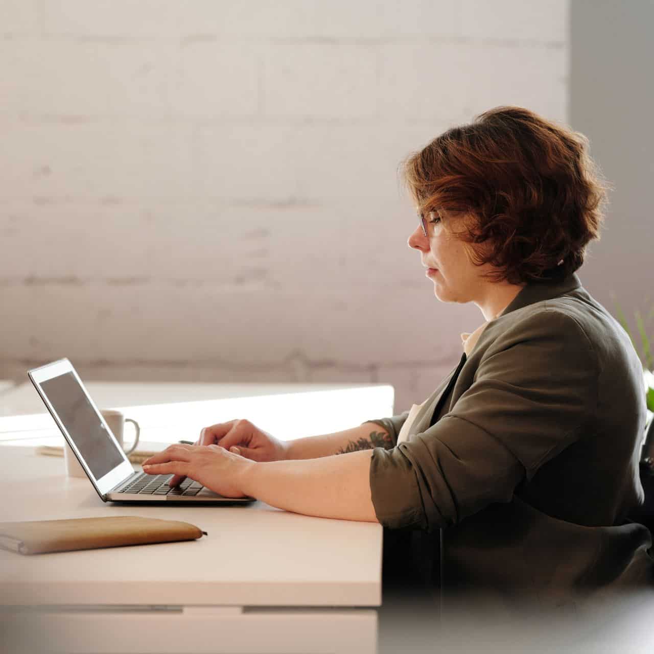 woman in wheelchair at desk with laptop