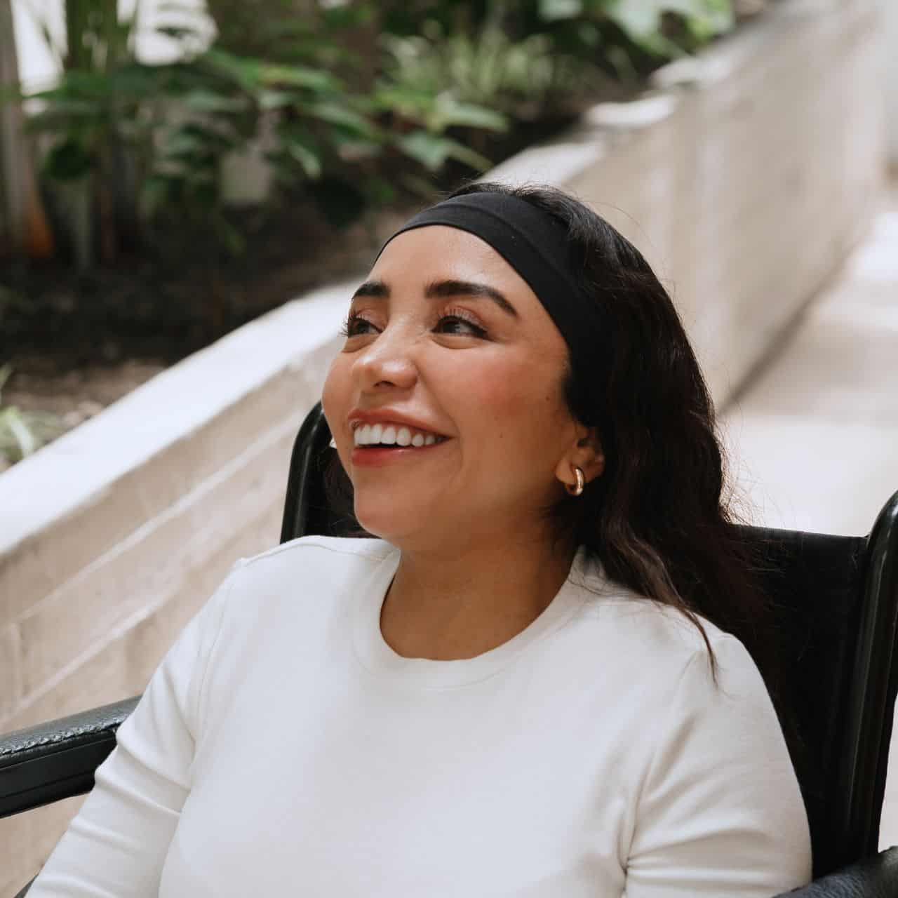 women outside in her wheelchair while smiling at friend